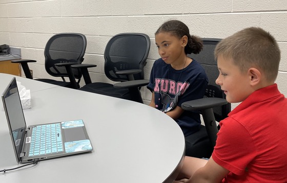 Students sitting in front of a computer