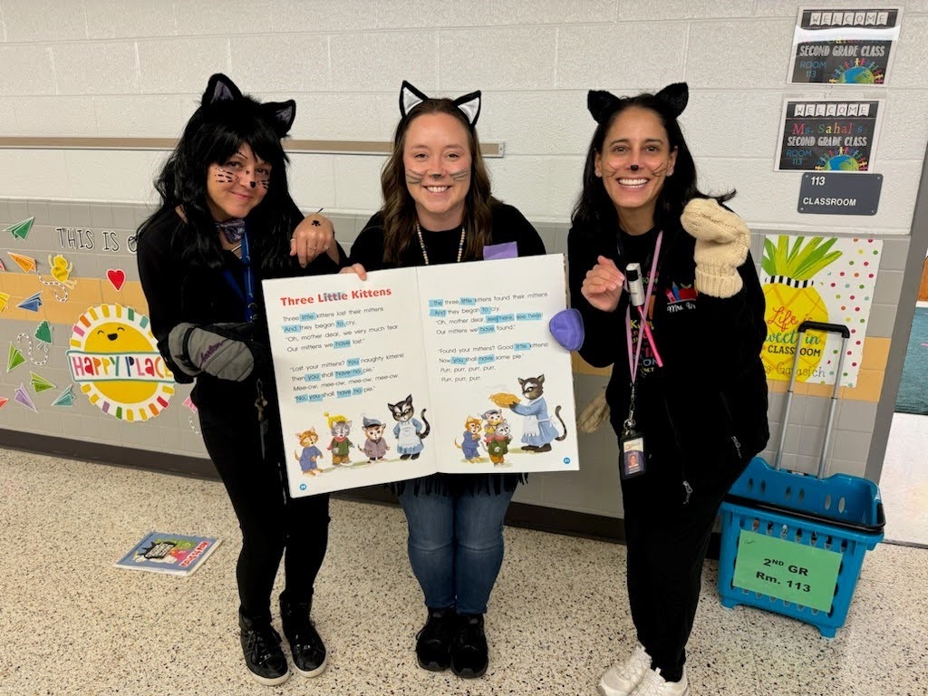 three teachers dressed as black cats