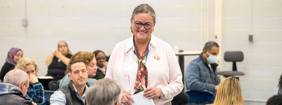 Dr. Reid smiling as she listens to someone speak