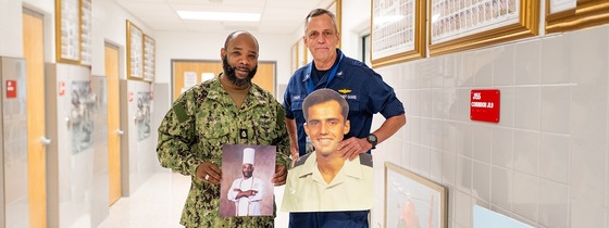 two employees stand with photos of their younger selves in the military