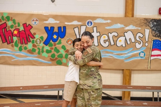 service member hugging her child