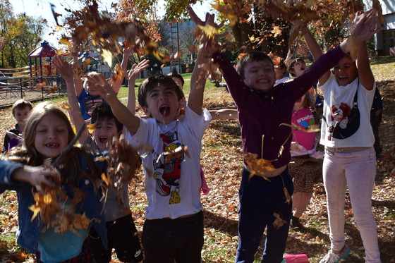 Students having Autumn fun in the leaves on the Franklin Sherman playground.