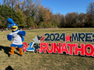 Photo of Roadrunner mascot with the Runathon 2024 sign