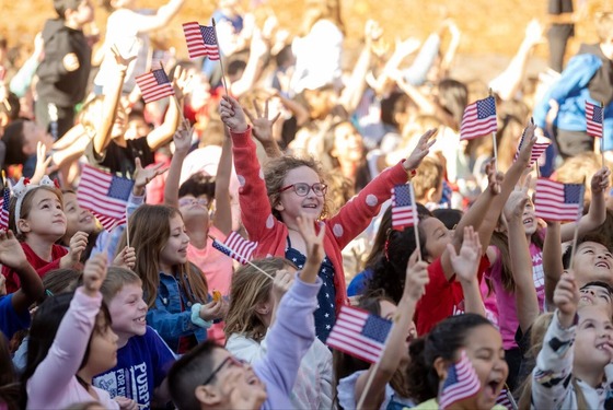 students wave American flags