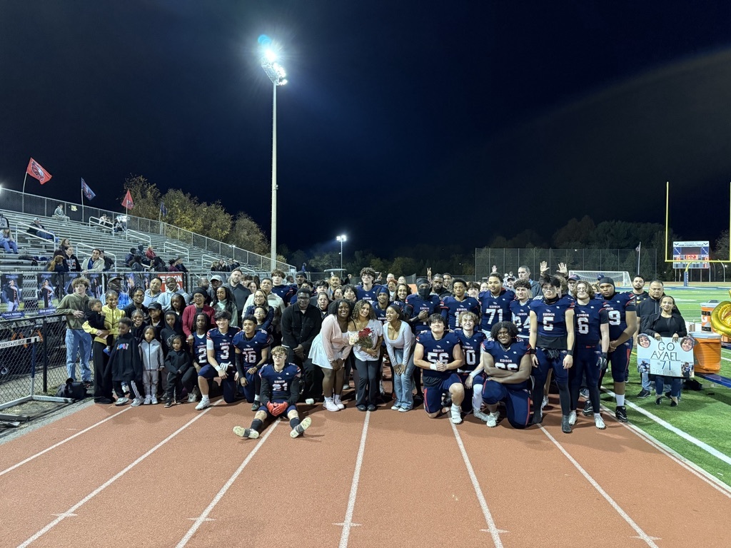 Football players standing on the track with their parents