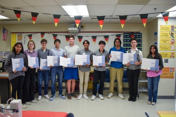 High school students standing together holding certificates