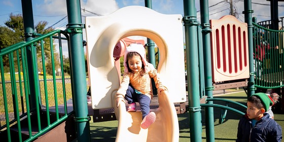 student going down a slide on a playground