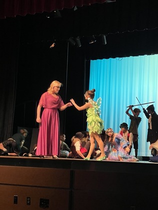 two students on stage, one dressed as tinkerbell