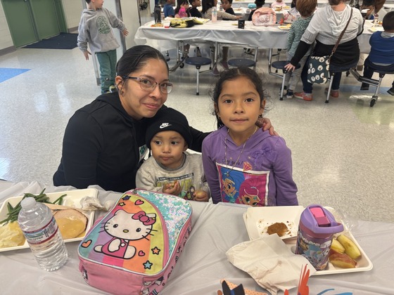 A parent and child smile during the Thanksgiving Luncheon