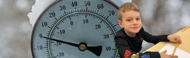 kid sitting in desk with thermometer and cold weather in the background