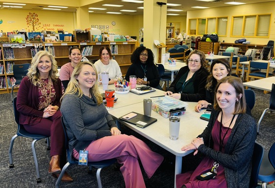 teachers sitting around a table for a literacy meeting