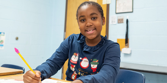 Picture of a student working happily at her desk.