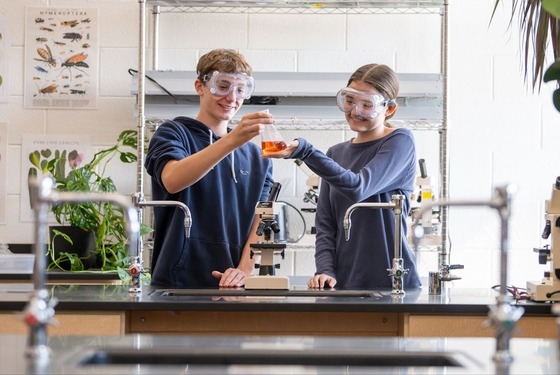 two students work on a science project in a lab