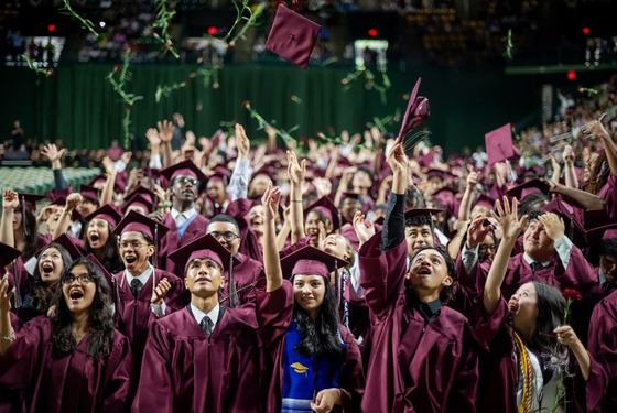 students in their cap and gowns celebrating graduation