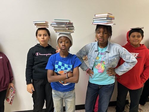 students with books on their heads