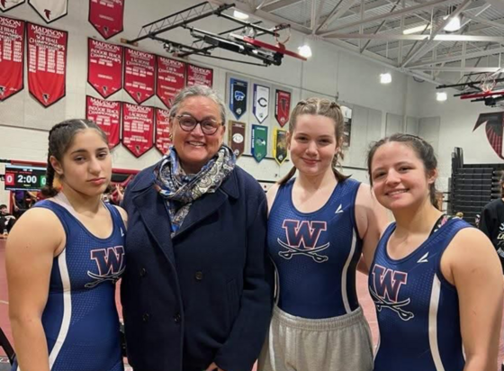 Girls Wrestling athletes take a picture with Dr. Reid at their match