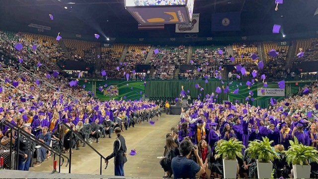 Graduates tossing their caps in the air at graduation ceremony