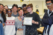 Ms. Grudi receives award surrounded by her students.