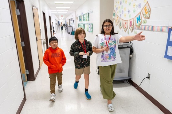 students shows other two students where to go in the hallway