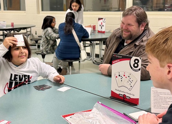 Student with father playing math game at Math Night