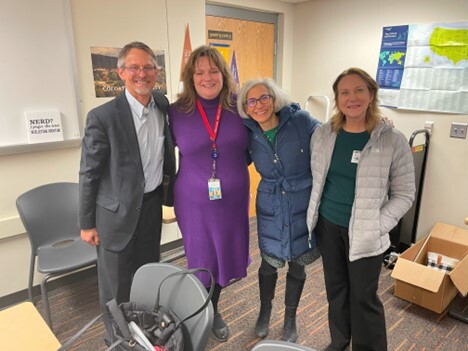 4 adults standing in a classroom posing for a photo