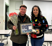 award winner holding their award and smiling with their principal