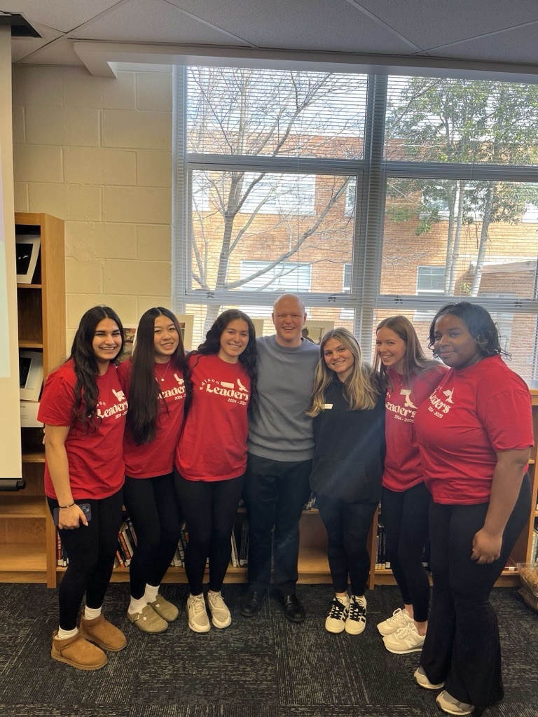 leadership students standing together in front of a window