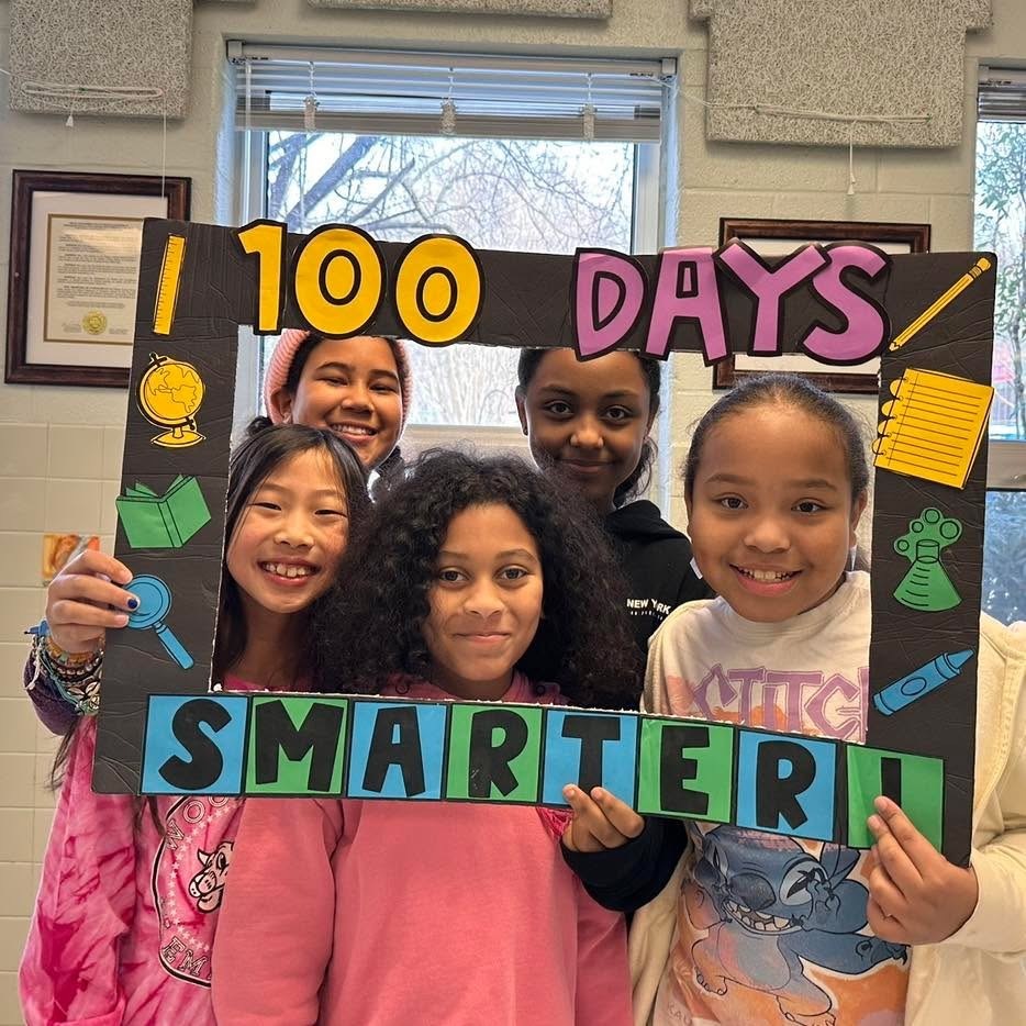 Students pose in a frame for the 100th day of school