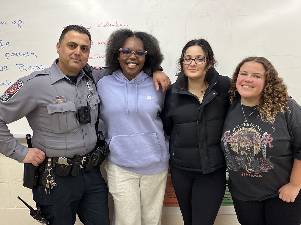 police officer posing with students