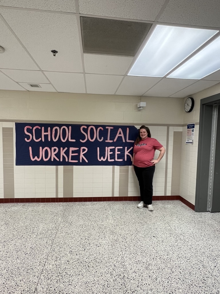 an adult standing in front of a sign that says school social worker week