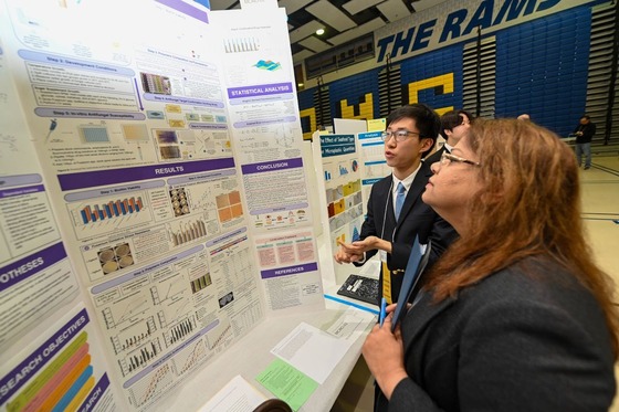 student shows off his tri-fold science project