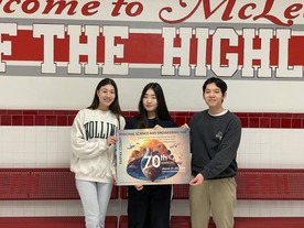 Three people holding a poster in front of a red and white wall with large text.  Transcribed Text from Poster: REGIONAL SCIENCE AND ENGINEERING FAIR 