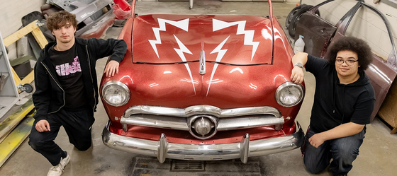 students pose next to a car they fixed up