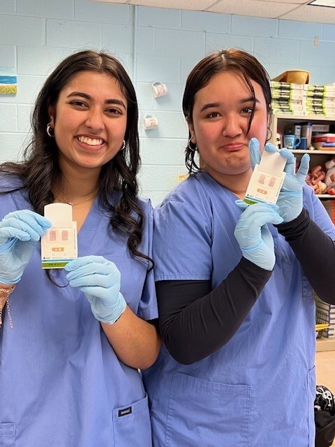 Students holding a culture test kit