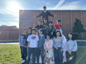 Group of people posing in front of a building with "MCLEAN HIGH SCHOOL" sign.