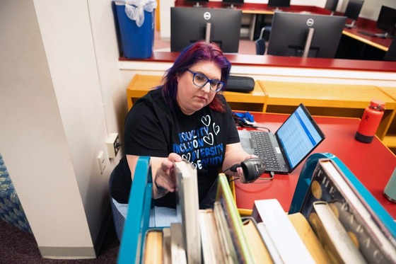 Librarian putting books back on a shelf