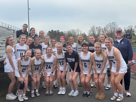 Girls Lacrosse team takes a group picture with Dr. Reid