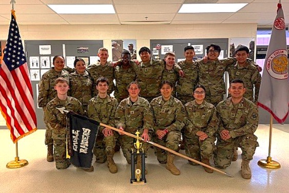 JROTC students standing together between the USA flag and the Edison HS flag