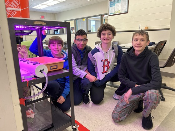 students kneeling next to a cart