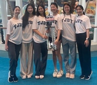 Students standing together holding trophy
