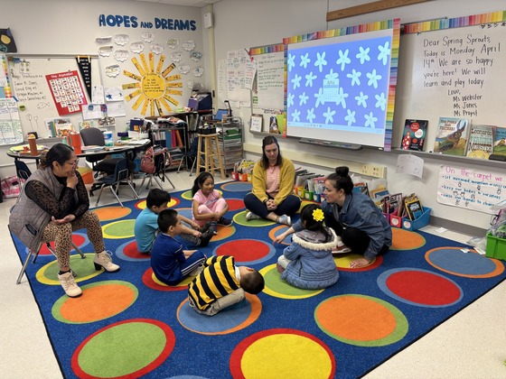 Students sit in a circle with their teachers 