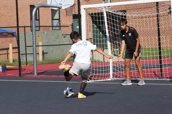 Vienna Youth Soccer participant kicks ball into goal