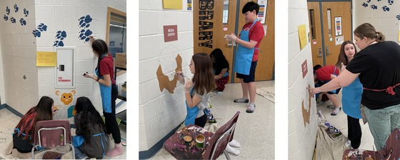 Students painting murals near the library with art teacher Mrs. Carlson