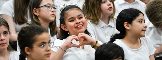 student holds a hand heart