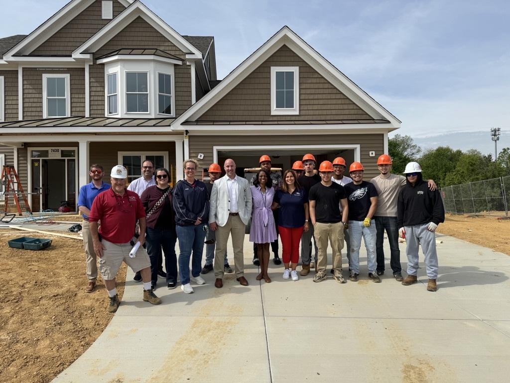 people standing in front of a newly built home