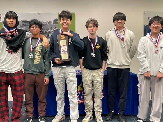 Students standing with trophy and medals