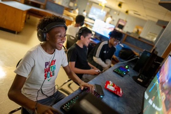 student playing video games across from a personal computer