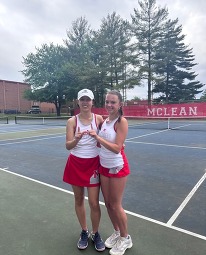 Two tennis players in red and white uniforms on a court, with a "MCLEAN" banner in the background.