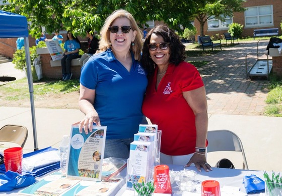 two employees smiling at their outdoor booth