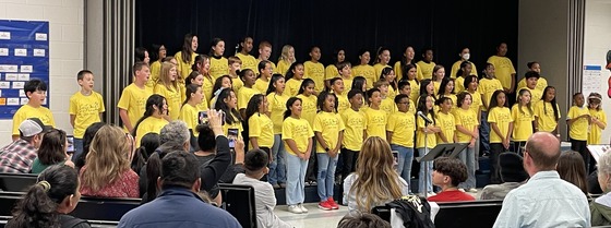 Chorus performing for families in their yellow Lane Lion Chorus shirts